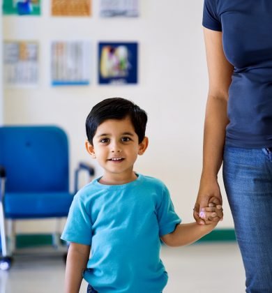 A realistic photo of a 3-year-old Indian boy standing in a bright, clean clinic or hospital setting 06-05-2025 at 11-53-24